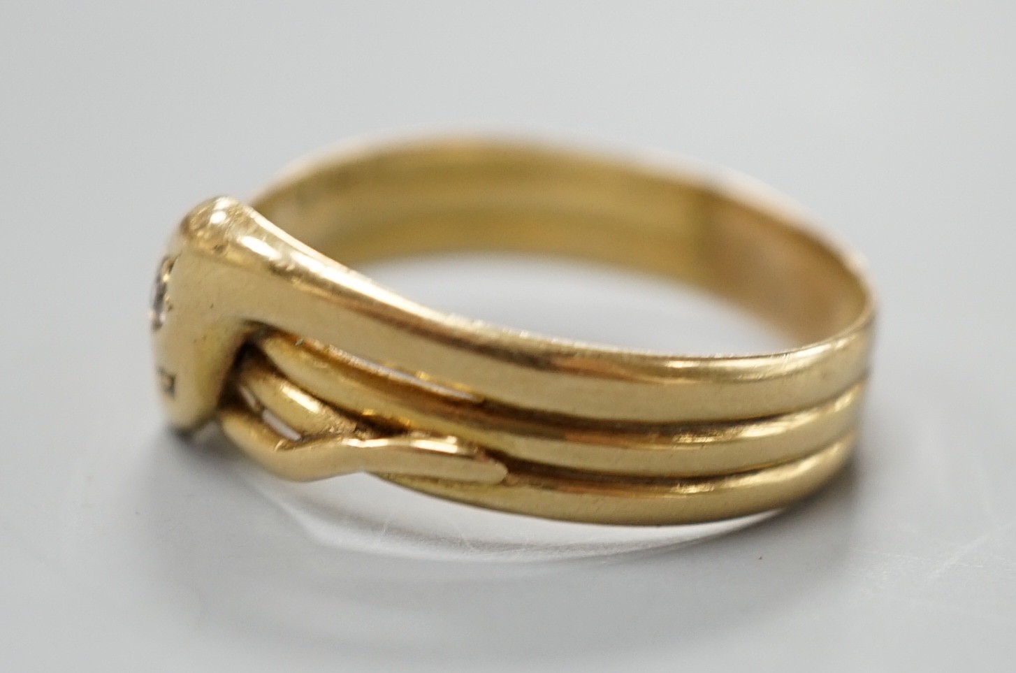 An Edwardian 18ct gold and diamond chip set serpent ring, size X/Y, gross 5.6 grams.